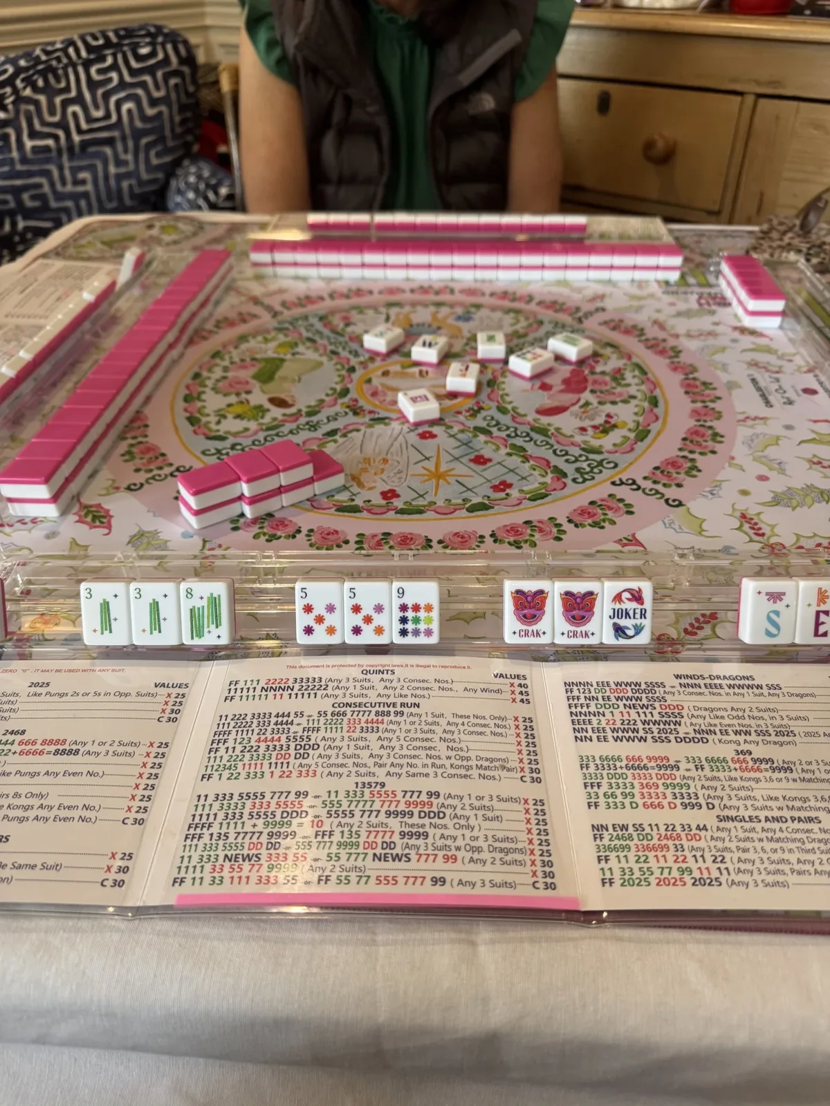 American mahjong tiles and an NMJL card on a floral game mat at Lucky Tiles Mahjong